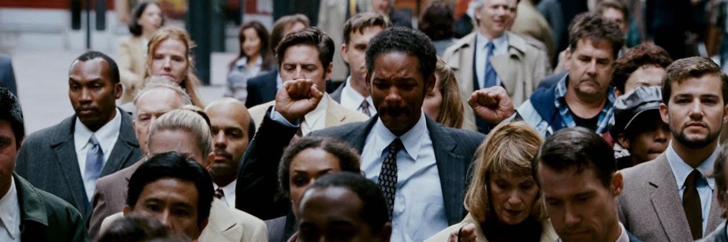 Chris Gardner walking through a crowd, clapping silently with tears running down his face